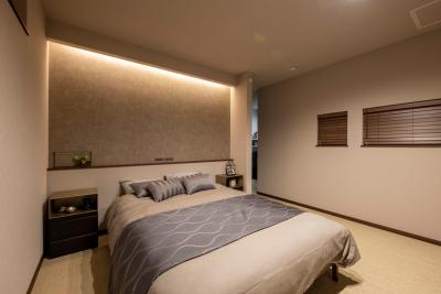寝室：ベッドヘッドの上部の間接照明が部屋をやわらかく照らし、くつろぎの空間に。