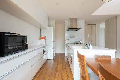 キッチン：白で統一され、清潔感あふれ、収納豊富な機能美を備えたキッチン。