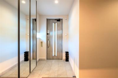 玄関：シューズボックスの扉には鏡を採用。お出かけ前のチェックや空間を広く見せる視覚効果も
