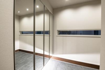 玄関：シューズボックスの扉に鏡を採用、空間に広がりを感じる