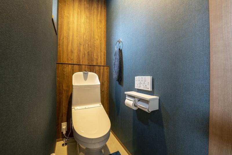 2階のトイレは両サイドにネイビーのクロスを、正面はアクセントに木目調のクロスを採用