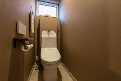 トイレ：背面は壁をふかし、両サイドに収納スペースをプラン