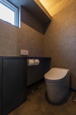 トイレ：床と壁紙はグレーでコーディネート。間接照明でデザインをプラス
