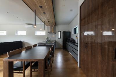 ダイニング、キッチン：グレーキッチンと木目の素材感が心地よい空間を演出
